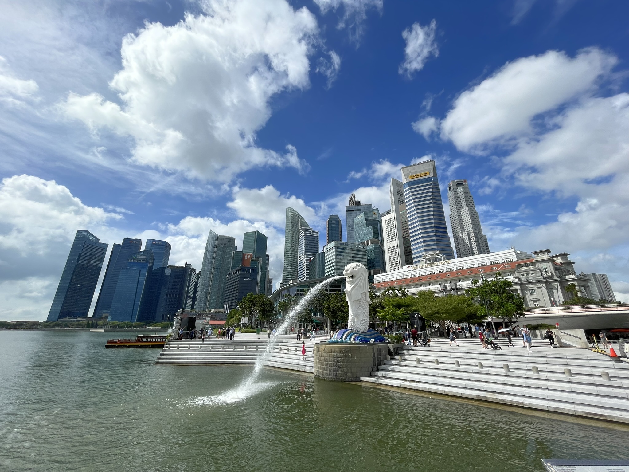 The Merlion statue spouting water against the Marina Bay skyline in Singapore.