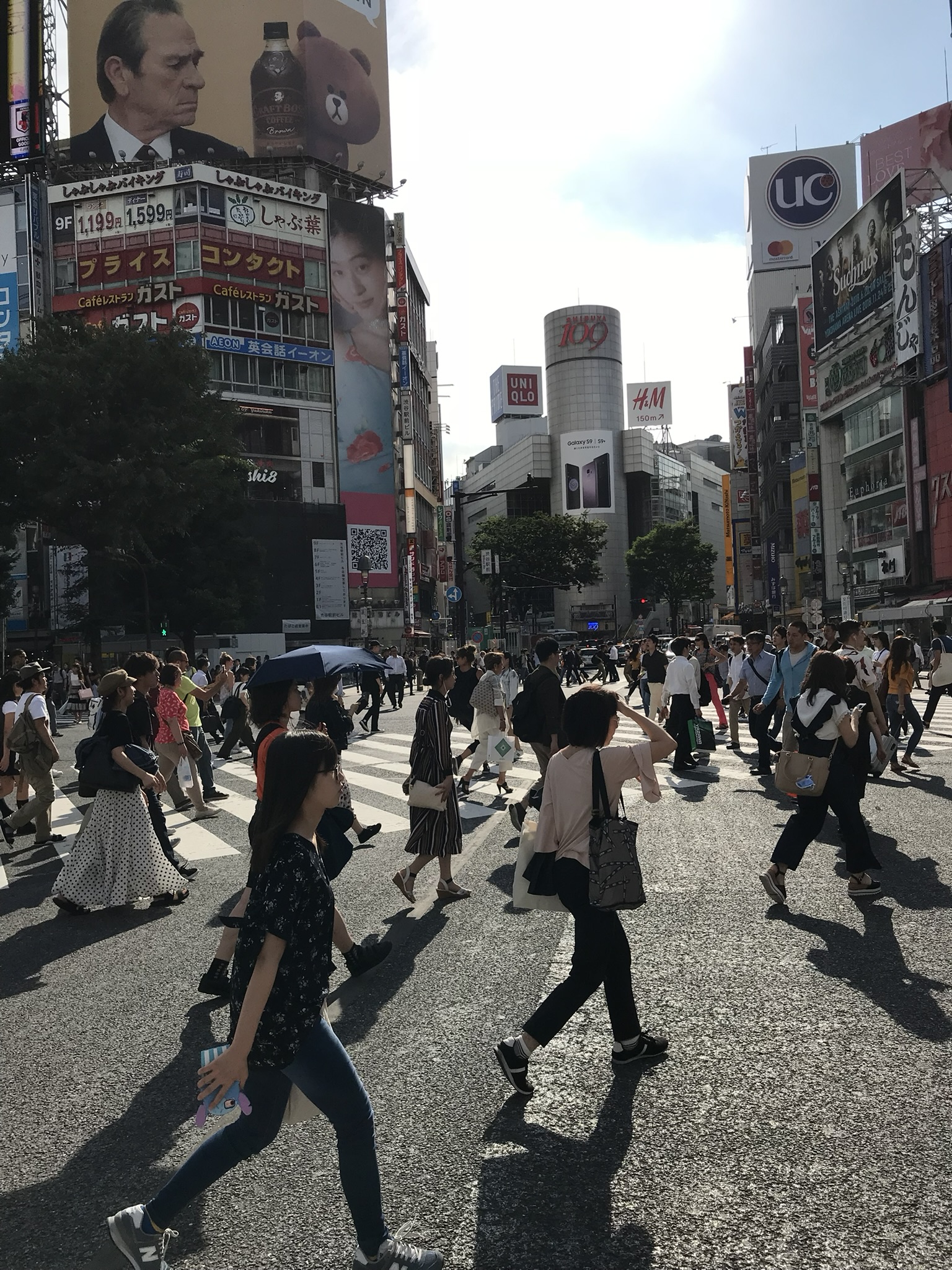 Bustling Shibuya crossing and city lights in Tokyo, Japan.