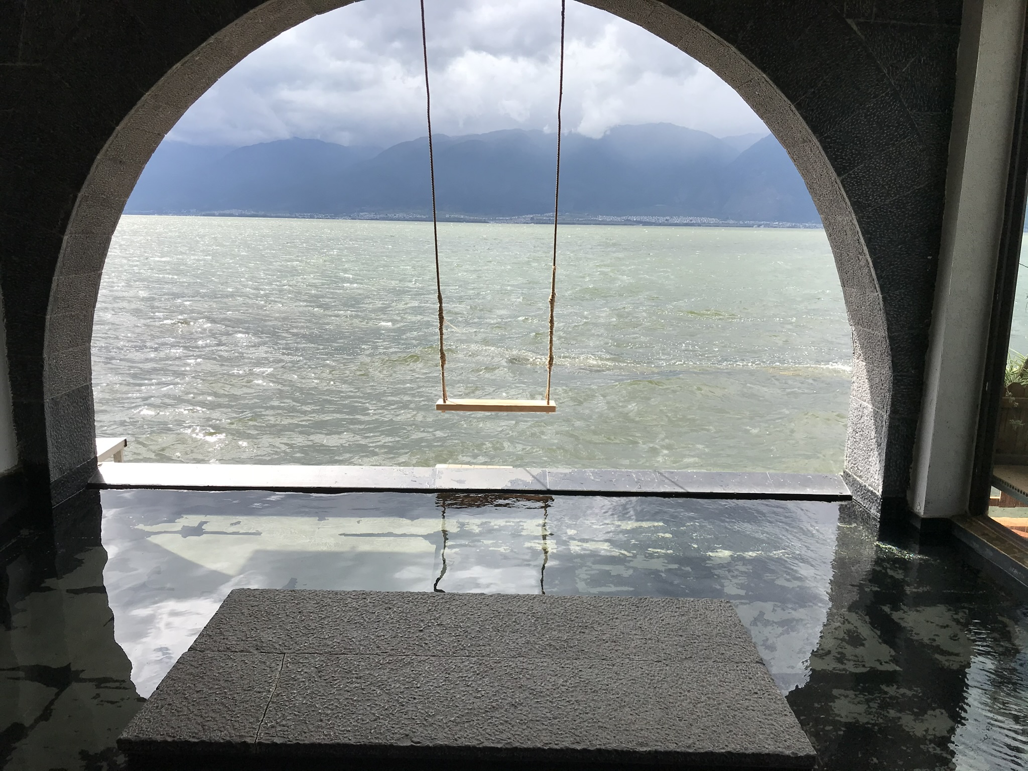 Tranquil waters of Erhai Lake with distant mountains in Dali, China.