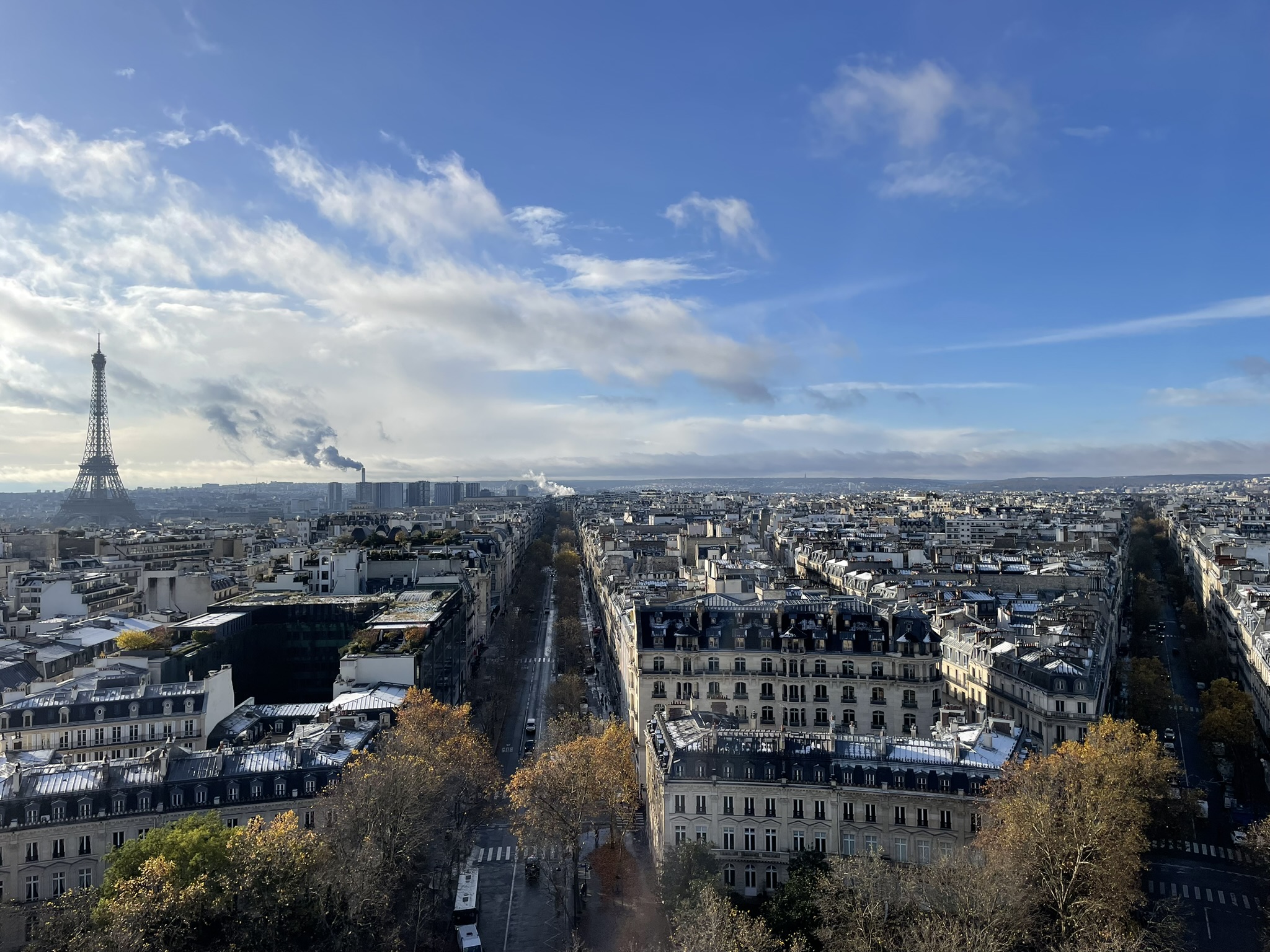 Tree-lined boulevard of the Champs-Élysées stretching toward the Arc de Triomphe in Paris, France.